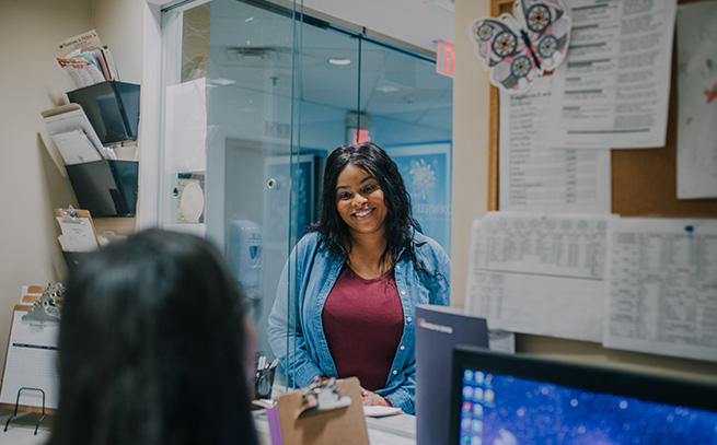 a woman patient chatting with the front desk receptionist