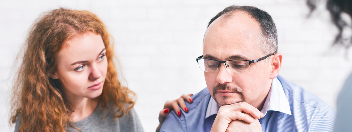  Supportive wife comforting husband with TRD during a meeting with a counselor in Monmouth Junction.